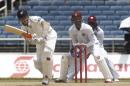 New Zealand's batsman Kane Williamson, left, plays a shot as West Indies wicket keeper Denesh Ramdin center, and Chris Gayle, right back, looks on during the opening day of their first cricket Test match in Kingston, Jamaica, Sunday, June 8, 2014. (AP Photo/Arnulfo Franco)