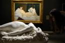 A visitor looks at a sculpture infront of Edouard Manet's "Olympia" during the exhibition "Splendour and Misery" at the Orsay Museum in Paris on January 21, 2015