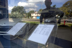 A man is reflected in the window of a car dealership&nbsp;&hellip;