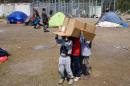 Migrant children play with a cardboard box at a makeshift camp at the Serbian-Hungarian border near the village of Horgos