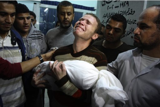 FILE - In this Nov. 14, 2012 file photo, Jihad Masharawi weeps while he holds the body of his 11-month old son Ahmad, at Shifa hospital following an Israeli air strike on their family house, in Gaza City. A U.N. report indicates an errant Palestinian rocket, not an Israeli airstrike, likely killed the baby of Masharawi during fighting in the Hamas-ruled territory last November. The death of Omar al-Masharawi, became a symbol of what Palestinians see as Israeli aggression during eight days of fighting that killed more than 160 Palestinians and six Israelis. (AP Photo/Majed Hamdan, File)