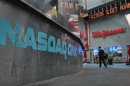 The Nasdaq logo is seen on the exterior of the Nasdaq MarketSite as a headline about the Facebook stock scrolls on the Times Square Newsticker, in New York