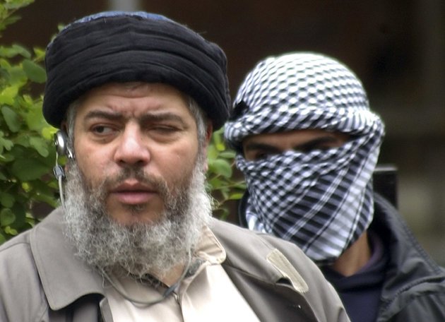 FILE - This Friday, April 30, 2004 file photo shows Muslim cleric Abu Hamza al-Masri, as he arrives with a masked bodyguard, right, to conduct Friday prayers in the street outside the closed Finsbury Park Mosque in London. A British court is expected to rule on whether extremist cleric Abu Hamza al-Masri is too ill to be extradited to the United States to face terror charges. London's High Court is set to decide Friday Oct. 5, 2012 whether al-Masri and other terror suspects can be sent to the U.S. to face charges that include helping set up a terrorist training camp in rural Oregon. (AP Photo/Max Nash, File)