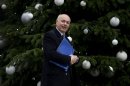 FILE - In this Dec. 4, 2012 file photo, Britain's Secretary for Work and Pensions Iain Duncan Smith looks to the media as he walks past the Christmas tree in Downing Street ahead of a cabinet meeting in London. Opponents of a raft of welfare changes want Smith to make good on a claim that he could live on the 53 pounds ($80) a week that one benefits recipient says he has left over after paying for housing and heat. (AP Photo/Alastair Grant, File)