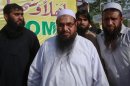 Hafiz Saeed, the head of Jamaat-ud-Dawa and founder of Lashkar-e-Taiba, gestures to the media as he arrives to attend a rally organised by the Defense Council of Pakistan in Lahore