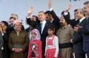 Turkish Prime Minister Recep Tayyip Erdogan (C), Iraqi Kurdish leader Massud Barzani (2nd L) and Kurdish singer Sivan Perwer (3rd R) appear on stage on November 16, 2013 in the southeastern Turkish city of Diyarbakir