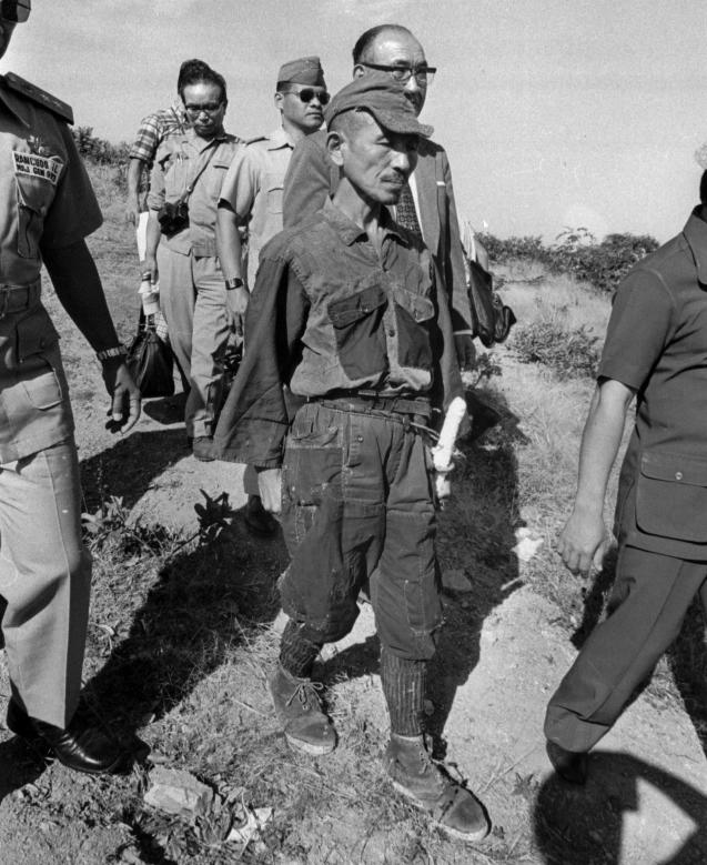 FILE - In this March, 1974 file photo, Hiroo Onoda, wearing his 30-year-old imperial army uniform, cap and sword, walks down a slope as he heads for a helicopter landing site on Lubang Island for a flight to Manila when he comes out of hiding in the jungle on the island, Philippines. Onoda, the last Japanese imperial soldier to emerge from hiding and surrender after World War II, has died. He was 91. Onoda died Thursday, Jan. 16, 2014 at a Tokyo hospital. (AP Photo)