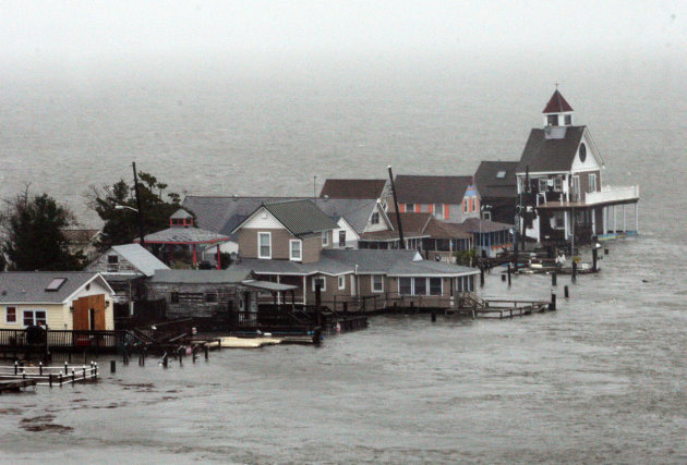 <p>               A row of houses stands in floodwaters at Grassy Sound in North Wildwood, N.J., as Hurricane Sandy pounds the East Coast Monday Oct. 29, 2012. The powerful storm made the westward lurch and took dead aim at New Jersey and Delaware on Monday, washing away part of the Atlantic City boardwalk, putting the presidential campaign on hold and threatening to cripple Wall Street and the New York subway system with an epic surge of seawater. (AP Photo/The Press of Atlantic City, Dale Gerhard) MANDATORY CREDIT