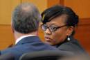 Defendant Dana Evans talks to her attorney, Robert Rubin, during the prosecution's opening statement in a case against 12 former Atlanta Public Schools educators and administrators, in Atlanta, Monday, Sept. 29, 2014 in Fulton County Superior Court. Prosecutors said 12 former Atlanta Public Schools educators and administrators cheated, lied and stole as part of a widespread but cleverly disguised conspiracy to inflate state test scores that affected thousands of students. Prosecutors have agreed to plea deals with 21 other defendants included in the initial indictment. (AP Photo/Atlanta Journal-Constitution, Kent D. Johnson, Pool)