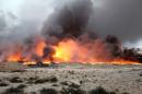 Fire rises from oil wells, set ablaze by Islamic State militants before fleeing the oil-producing region of Qayyara