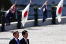 Australia's PM Abbott reviews a guard of honour with Japan's PM Abe during a welcome ceremony hosted by Abe at the state guest house in Tokyo