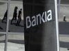 Pedestrians are reflected in the Bankia headquarters building in Madrid