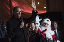 US President Barack Obama waves during the annual National Christmas Tree Lighting ceremony on the Ellipse in Washington on December 4, 2014