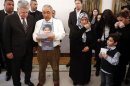 German President Gauck listens to a statement made by Yozgat, who displays a picture of his son Halit killed by the small neo-Nazi group National Socialist Underground during a meeting with relatives of the victims in Berlin