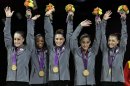 U.S. gymnasts, left to right, Jordyn Wieber, Gabrielle Douglas, McKayla Maroney, Alexandra Raisman, Kyla Ross raise their hands on the podium during the medal ceremony during the Artistic Gymnastic women's team final at the 2012 Summer Olympics, Tuesday, July 31, 2012, in London. Team U.S. won the gold. (AP Photo/Gregory Bull)