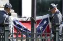 An honor guard from the South Carolina Highway patrol lowers the Confederate battle flag as it is removed from the Capitol grounds Friday, July 10, 2015, in Columbia, S.C. The Confederate flag was lowered from the grounds of the South Carolina Statehouse to the cheers of thousands on Friday, ending its 54-year presence there and marking a stunning political reversal in a state where many thought the rebel banner would fly indefinitely. (AP Photo/John Bazemore)
