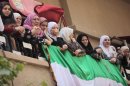 Women stand on the balcony as they watch a protest against President Bashar al-Assad after Friday prayers in Raqqa province, east Syria