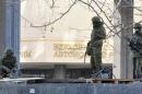 Unidentified armed men patrol in front of the Crimean Parliament in Simferopol, on March 1, 2014