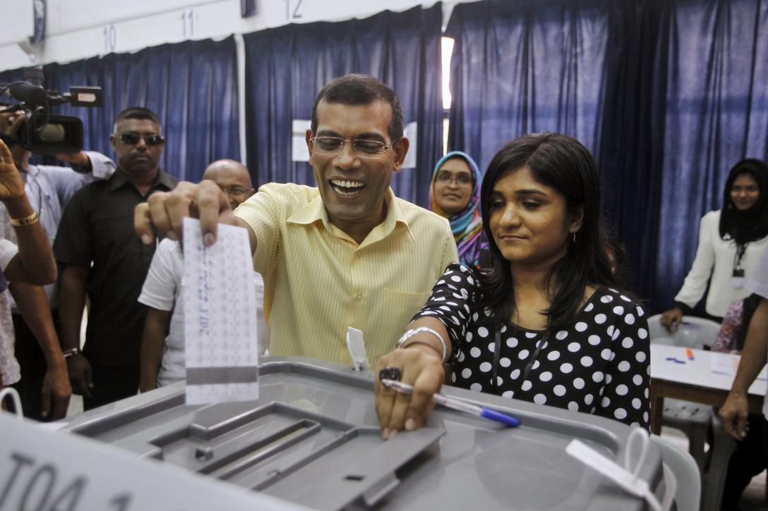 Maldives' former President and candidate in the presidential elections Mohamed Nasheed, center left, casts his vote in Male, Maldives, Saturday, Nov. 9, 2013. After two months of political bickering and repeated failure to hold an election, Maldives voters headed to the polls Saturday to elect a new president for their vulnerable new democracy. (AP Photo/Sinan Hussain)