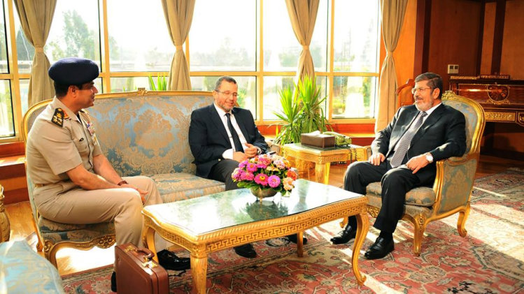 FILE - In this file photo released by the Egyptian Presidency Monday, July 1, 2013, Egyptian President Mohammed Morsi, right, meets with Prime Minister Hesham Kandil, center, and Egyptian Minister of Defense, Lt. Gen. Abdel-Fattah el-Sissi, left in Cairo, Egypt. "Over my dead body!" Mohammed Morsi told his army chief who came to him asking the Islamist president to step down on his own and not resist a military ultimatum and the demands of giant crowds out in the streets. Morsi found himself isolated, with trusted aides abandoning him, and in the end, the ring of Presidential Guards protecting him simply stepped away to allow the military to take him under its custody, according to army, security and Brotherhood officials giving The Associated Press an account of his last hours.(AP Photo/Egyptian Presidency, File)