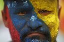 A supporter of Venezuela's acting President Nicolas Maduro stands with his face painted in the colors of his nation's flag outside the national electoral council where Maduro registers his candidacy for president to replace late President Hugo Chavez in Caracas, Venezuela, Monday, March 11, 2013. Presidential elections were announced to take place on April 14, after Maduro announced on March 5 that Chavez had died. (AP Photo/Rodrigo Abd)