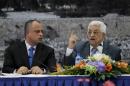 Palestinian Authority President Mahmoud Abbas (R) attends a meeting in the West Bank city of Ramallah on October 7, 2013