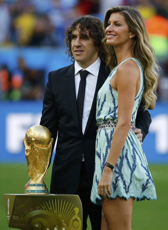 Puyol and Brazilian supermodel Bundchen pose with the World Cup trophy before the 2014 World Cup final in Rio de Janeiro