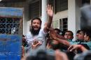 A Bangladesh soldier waves to photographers following the announcement of his death penalty at the special court in Dhaka, on November 5, 2013