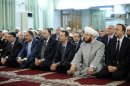 In this photo released by the Syrian official news agency SANA, President Bashar Assad, third right in front row, alongside Syria's grand mufti, second right, prays at the start of Eid al-Fitr, the three-day holiday that ends the holy month of Ramadan at the Anas bin Malik Mosque, Damascus, Syria, Thursday Aug. 8, 2013. Mortar rounds on Thursday hit an upscale district of Damascus where Assad attended prayers to mark the start of a major Muslim holiday in a rare attack in the high security area. (AP Photo/SANA)