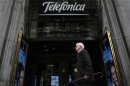 A man walks past Telefonica's building in central Madrid
