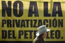 An activist stands in front a banner during a political meeting organized by PRD to present a proposal to the energy reform bill in Mexico City
