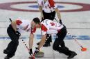 Canada's Brad Jacobs, back, watches as Ryan Harnden, left, and E.J. Harnden, right, sweep the ice during the men's curling match against the United States at the 2014 Winter Olympics, Sunday, Feb. 16, 2014, in Sochi, Russia. (AP Photo/Wong Maye-E)