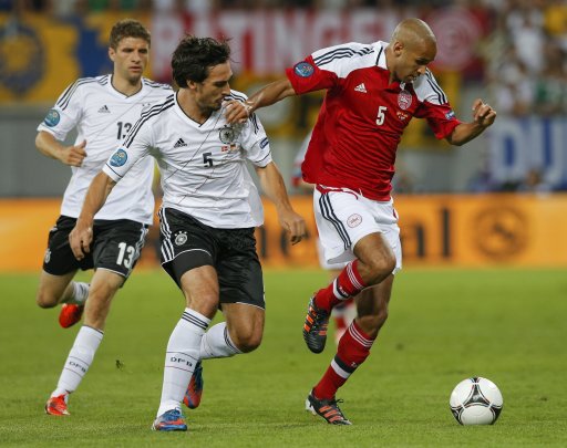 Germany's Hummels fights for the ball with Denmark's Poulsen as Germany's Mueller runs up during their Euro 2012 Group B soccer match at the new stadium in Lviv