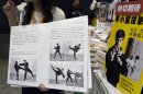 A shopkeeper introduces a latest Chinese edition of "Bruce Lee's Fighting Method" by the late Kung Fu legend Bruce Lee on the first day of the week-long Hong Kong Book Fair