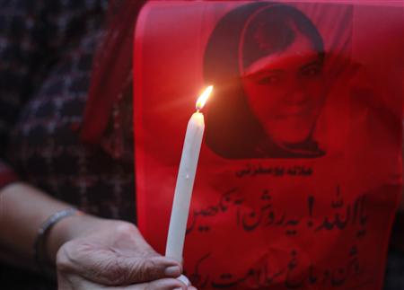 A woman holds a picture of Malala Yousufzai with a candle as she participates in a rally to condemn the attack on Yousufzai, in Karachi October 11, 2012. REUTERS/Athar Hussain