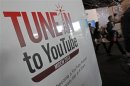 Visitors walk past a YouTube stand during MIDEM in Cannes