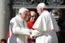 Pope Francis greets Emeritus Pope Benedict XVI before a mass in Saint Peter's square at the Vatican