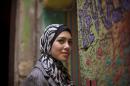 In this Tuesday, Dec. 10, 2013 photo, Egyptian rapper Myam Mahmoud poses for a portrait in downtown Cairo. Mahmoud, an 18-year-old Egyptian, rapped her way to the semi-finals of the Middle East's hit TV show 