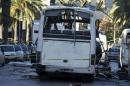 Tunisian forensics police inspect a Tunisian presidential guard bus at the scene of a suicide bomb attack in Tunis