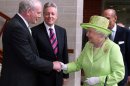 Britain's Queen Elizabeth II shakes hands with Northern Ireland Deputy First Minister and former IRA commander Martin McGuinness watched by First minister Peter Robinson, centre, at the Lyric Theatre in Belfast, Northern Ireland, Wednesday, June 27, 2012. (AP Photo/Paul Faith/pool)