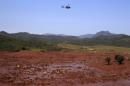 A helicopter flies over the Bento Rodrigues district, covered with mud after a dam owned by Vale SA and BHP Billiton Ltd burst in Mariana