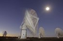 In this time exposure photo taken Monday, April 2, 2012, the moon and stars are seen above telescope dishes near the Karoo town of Carnarvon, South Africa, which is announced Friday May 25, 2012, as the site of the proposed Square Kilometre Array (SKA) radio telescope project. A giant radio telescope made up of some 3,000 separate 15-meter (49-foot) diameter dishes and intended to help scientists answer fundamental questions about the make-up of the universe will be built and based in both Australia and South Africa, the international consortium overseeing the project announced Friday. (AP Photo/Schalk van Zuydam) EDS NOTE: TIME EXPOSURE CAUSING BLUR AS TELESCOPE DISHES MOVE