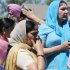 Bystanders stand outside the scene of a shooting inside The Sikh Temple in Oak Creek, Wis, Sunday, Aug. 5, 2012. Police in Wisconsin say at least seven people are dead at a Sikh temple near Milwaukee, including the suspected gunman. (AP Photo/Jeffrey Phelps)