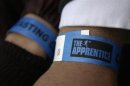 Potential contestants show arm bands while waiting to try out for new Apprentice shows.