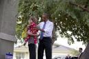 President Barack Obama visits with a woman and child after speaking outside a home in a housing development, Thursday, Jan. 8, 2015, in Phoenix. (AP Photo/Carolyn Kaster)