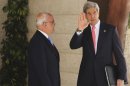 U.S. Secretary of State Kerry waves as he stands next to Palestinian Chief Negotiator Erekat in Ramallah