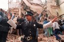 A policeman prevents people from approaching the site where a powerful explosion destroyed a seven storey building housing, the Jewish Mutual Association of Argentina, in Buenos Aires on July 18, 1994