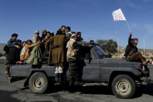 Houthi fighters ride a patrol truck in Sanaa