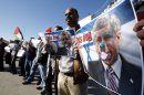 Palestinians hold pictures of Canadian Prime Minister Stephen Harper superimposed with a face of a dog during a protest following his remarks about the Palestinian UN bid for an observer state status, in front of Canadian representative offices in the West bank city of Ramallah, Wednesday, Nov. 28, 2012. Harper has threatened "there will be consequences" if Palestinian Authority President Mahmoud Abbas does not end his campaign for the Palestinian Authority to be recognized by the UN as a non-member observer state. (AP Photo/Majdi Mohammed)