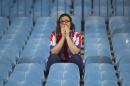 An Atletico supporter reacts after the team lost the Champions League final soccer match, taking place in Portugal, between Real Madrid and Atletico Madrid, in Madrid, Spain, Saturday, May 24, 2014. (AP Photo/Gabriel Pecot)